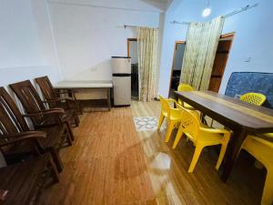a dining room with a table and yellow chairs at New Eagle Best Inn in Haputale