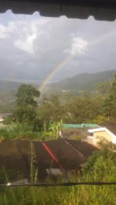 a rainbow in the sky over a house with at New Eagle Best Inn in Haputale