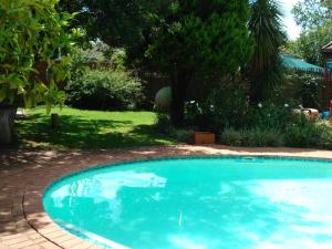 a large blue swimming pool in a yard at Anne's Place in Potchefstroom