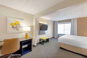 a hotel room with a bed and a desk and a television at Comfort Inn & Suites Arlington Heights - Schaumburg in Arlington Heights +45 photos