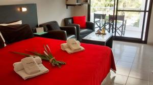 a room with a red bed with towels on it at Andaluhe Posada in Miramar