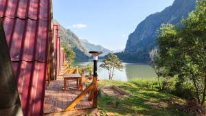 a wooden deck with a table and a view of a river at Papaya Resort Nong Khiaw in Nongkhiaw +21 photos