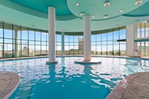 a swimming pool in a building with large windows at Turquoise Place Condos in Orange Beach