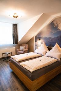 LahnauにあるDas kleine Hotel Lahnauの壁に絵が飾られた大きなベッドのある寝室