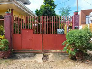 a red gate in front of a house at Peace Lily Studio Apartments Panglao in Panglao Island