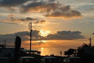 a sunset over the water with cars in a parking lot at Kokalakis Hotel in Kefalos