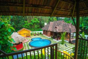 KodanadBethel Heritage Resort的享有后院、游泳池和房屋的景色