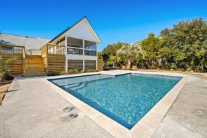 a house with a swimming pool in front of a house at High Seas in DeBordieu Colony home by Peace Vacations in Georgetown