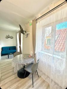 une salle à manger avec une table et une fenêtre dans l'établissement Dubrovnik sweet little corner apartment, à Dubrovnik