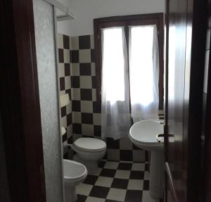 サンタ・テレーザ・ガッルーラにあるCase Vacanze Di Jakiのバスルーム(トイレ2つ、洗面台、窓付)
