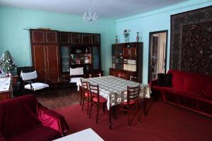 un soggiorno con un tavolo e un divano rosso di Family Hotel 7 Sisters a Kazbegi