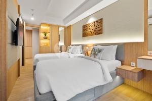 1 dormitorio con 2 camas blancas y TV en Olaia by Kozystay - Nusa Dua, en Nusa Dua 17 fotos más