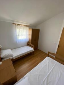 a small room with two beds and a window at Apartman Palma in Vir