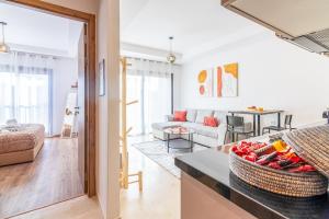 マラケシュにあるLivia cosy - Clim, Wifi, Jardin à 10min de l'Aéroportのソファとテーブルのあるリビングルーム