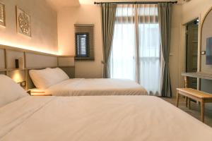 Posteľ alebo postele v izbe v ubytovaní Yuzhi Wenlv B&B