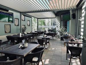 an empty restaurant with wooden tables and chairs at Soleil Apartman Szeged in Szeged