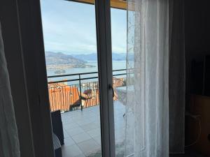 a door to a balcony with a view of the water at Nide House in Someraro +20 photos