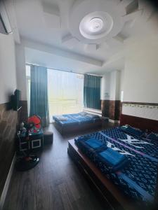 a bedroom with two beds and a large window at Hoàng Bách 3 Hotel in Ho Chi Minh City