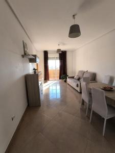 a living room with a couch and a table at APARTAMENTO TURISTICO 2ºD CARLOS III - Cerca de la playa in Roquetas de Mar