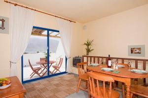 a dining room with a table and a balcony at Casa del Rio in Caleta de Sebo