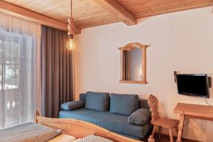 a living room with a blue couch and a table at Schwüwong - Apartment 12 in Kelchsau