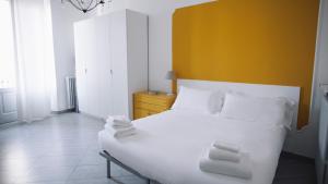 - une chambre avec un lit blanc et une tête de lit jaune dans l'établissement Italianway-Corso Sempione 96, à Milan