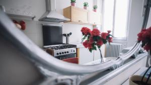 a kitchen with a stove and a vase of red flowers at Italianway-Corso Sempione 96 in Milan