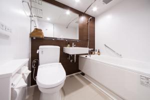a bathroom with a white toilet and a sink at HOTEL MYSTAYS PREMIER Kanazawa in Kanazawa