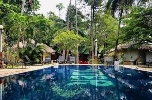 a swimming pool at a resort with trees in the background at Sunset Serenity D1 in Ko Phangan