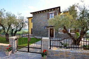 a stone house with a black fence and trees at Luxury Villa Maslina with private pool & jacuzzi in Šćulci