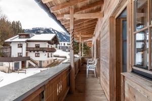 a balcony with a view of the snow covered mountains at Schwüwong - Apartment 13 in Kelchsau