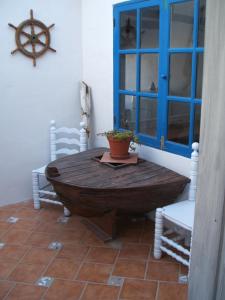 uma mesa de madeira num quarto com cadeiras e uma janela em Casa del Rio em Caleta de Sebo