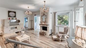 a living room with white walls and a fireplace at VILLA RUDY 8, Emma Villas in Padresergio