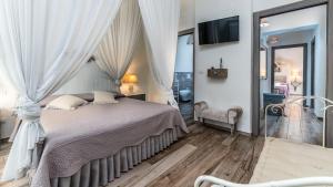 a bedroom with a bed with curtains and a tv at VILLA RUDY 8, Emma Villas in Padresergio +35 photos