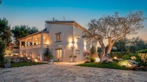 a large white house with a tree in the yard at VILLA RUDY 8, Emma Villas in Padresergio