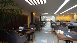 a dining room with wooden tables and chairs at Gurtas Hotel in Antalya