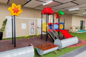 ein Spielzimmer mit einem Spielplatz mit Rutsche in der Unterkunft Homey and Good Place 2BR Transpark Bintaro Apartment By Travelio in Tangerang