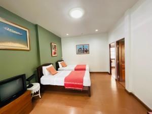 ein Schlafzimmer mit einem Bett und einem Fernseher in der Unterkunft Baan Klang Vieng in Chiang Mai