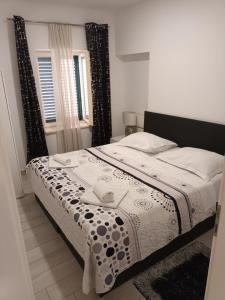 a bedroom with a bed with a black and white comforter at Stars Palace Vodice in Vodice