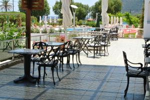 an outdoor patio with tables and chairs and a pool at Kokalakis Hotel in Kefalos