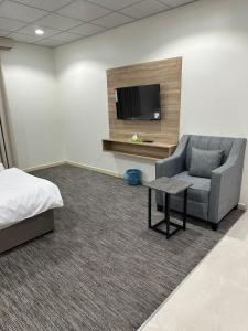 a room with a bed and a couch and a tv at الخالديه للشقق المخدومه in Al ‘Awālī
