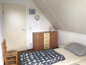 a attic bedroom with a bed and a dresser at Comfortable 6-person holiday home in Sint Maartenszee