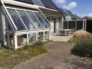 a glass house with a patio and a table at Comfortable 6-person holiday home in Sint Maartenszee
