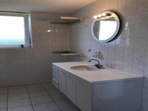 a bathroom with a sink and a mirror at Comfortable 6-person holiday home in Sint Maartenszee +25 photos
