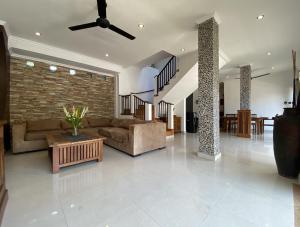 a living room with couches and a brick wall at Amazing Villa in Seminyak Petitenget Top Location in Seminyak