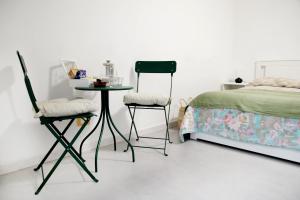 una camera da letto con un letto, due sedie e un tavolo di Mama's home a Napoli