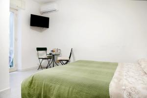 una camera da letto con un letto e un tavolo con sedie di Mama's home a Napoli Altre 4 foto