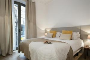 ein weißes Schlafzimmer mit einem großen Bett und einem Fenster in der Unterkunft Apartment in downtown Barcelona - Vintage in Barcelona