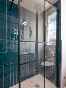 a bathroom with blue tiled walls and a shower at La Fantástica Pontedeume 1 in Puentedeume