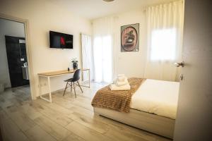a bedroom with a bed and a desk and a window at B&B Alèsia in Montesilvano